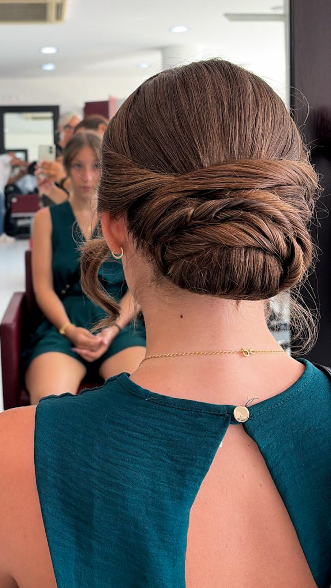 Chignon intrecciato per cerimonia su capelli mossi