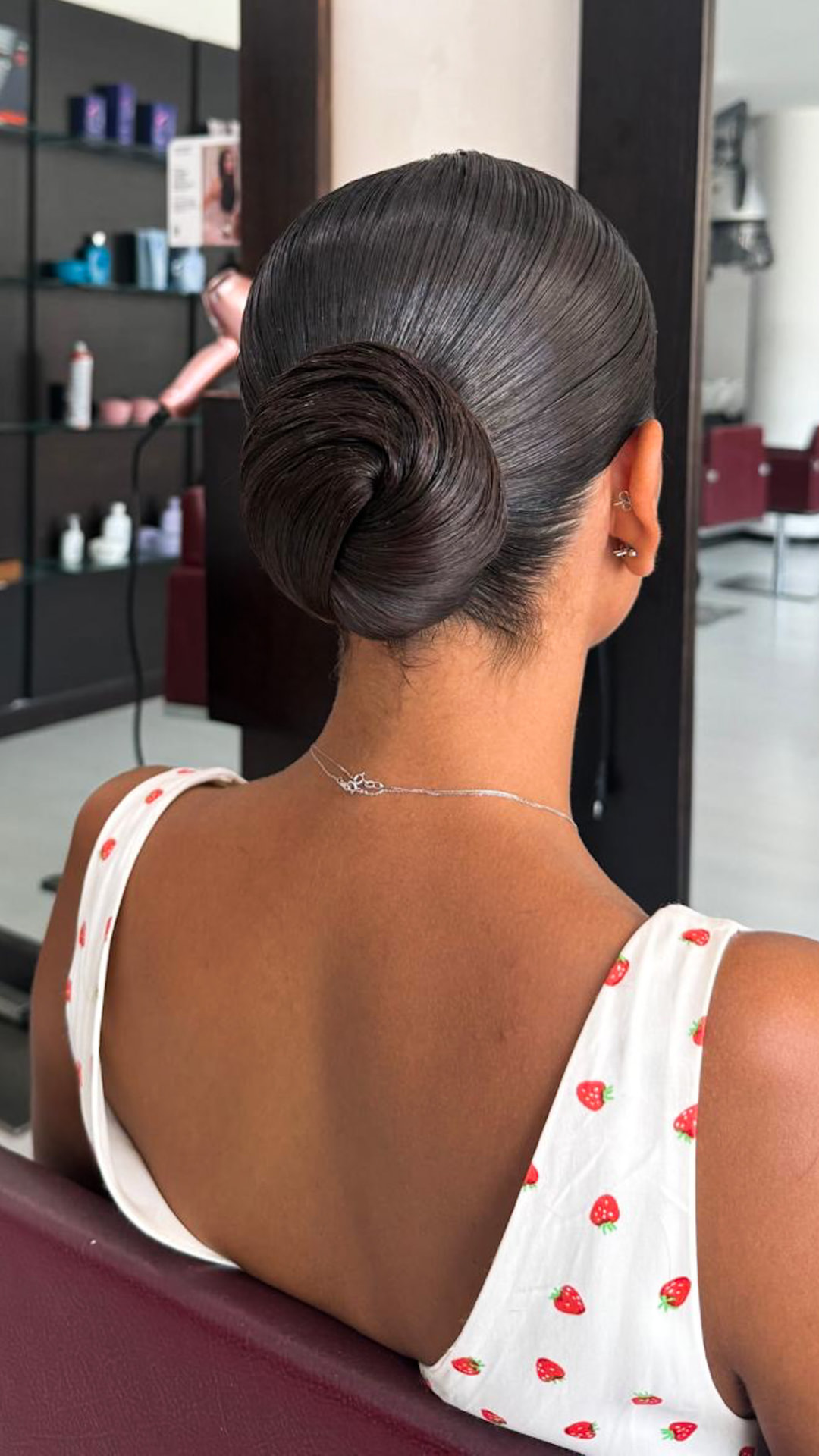 Chignon basso liscio e lucido su capelli scuri